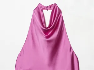 Detalle del top de satén magenta con cuello halter, cierre de botón y elegante escote fluido