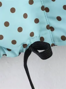 Close-up macro detail of black drawstring loop on light blue polka dot fabric garment
