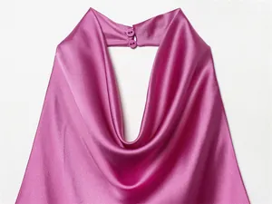Primer plano detallado de un elegante top halter de satén fucsia con botones en el cuello