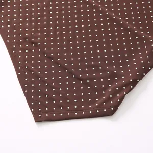 Detail des braunen Mesh-Halter-Tops mit funkelnden Strassverzierungen und Saumverarbeitung.