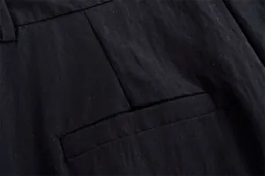 Macro view showing the pocket detail and fine linen texture of a black casual suit.