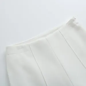 Gros plan montrant la ceinture et le pli vertical d'un pantalon de costume blanc large