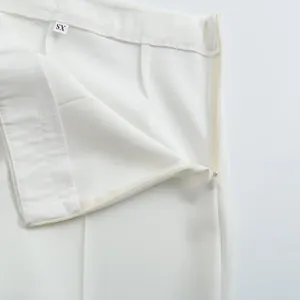 Détail du pantalon de costume blanc montrant le zip invisible et l'étiquette XS