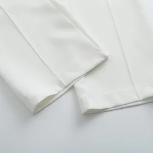 Détail de pantalon de costume blanc à jambes larges montrant les coutures et la texture