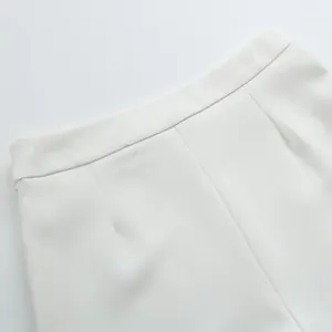 Détail rapproché de la taille d'un pantalon blanc élégant montrant la texture du tissu
