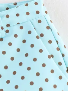 Close-up detail of light blue fabric with brown polka dots showing pocket and waistband
