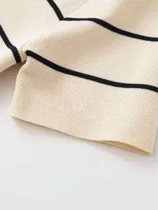 Close-up of the fine knit texture and horizontal black striped pattern on a cream fabric.