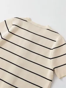Macro view of cream knitted crew neck top with thin black horizontal stripes detail