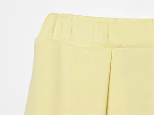 Vista macro ravvicinata della fascia elastica in vita e cuciture su pantaloncini gialli