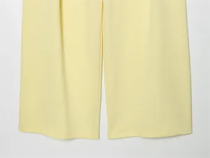 Dettaglio ravvicinato dell'orlo di pantaloni gialli a gamba larga con cuciture perfette