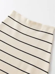 Close-up detail of a cream and black horizontal striped knit skirt with elastic waistband
