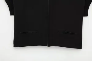 Nahaufnahme einer schwarzen Kurzjacke mit einem Reißverschluss und Paspeltaschen