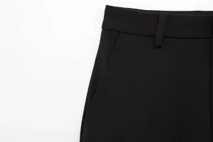 Detailaufnahme einer schwarzen Damenhose mit geradem Bein, Gürtelschlaufe und Tasche