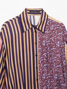 Dettaglio camicia da donna con bottoni, righe e stampa astratta in stile patchwork.