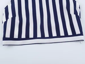 Macro detail showing the hem and side zipper of a navy blue and white striped summer top