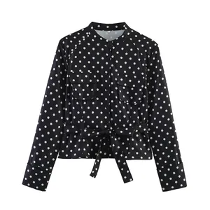 Detailansicht der modischen Damenjacke mit schwarz-weißen Punkten, Bindegürtel und Taschen