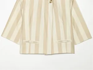 Détail d'un blazer d'été à manches courtes à rayures avec bouton et poches latérales