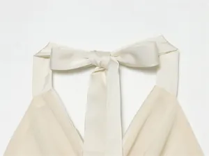 Vista detallada del top halter de satén crema con un elegante lazo en la espalda
