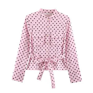 Detailansicht der rosa gepunkteten Bluse mit Brusttaschen und Taillenband.