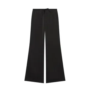 Vista detallada de pantalones de seda negros de pierna ancha con cordón y acabado satinado