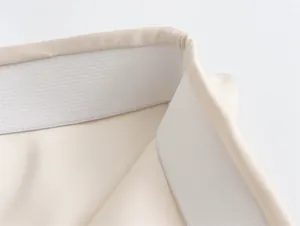 Detalle de la cinturilla elástica ancha en una falda larga de satén beige de estilo francés