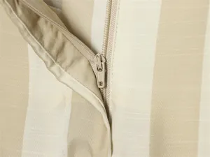 Détail macro montrant la fermeture éclair et la texture du tissu à rayures beige du pantalon