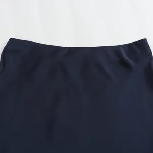 Primer plano de la textura de satén suave y la cintura alta de esta falda midi azul marino.