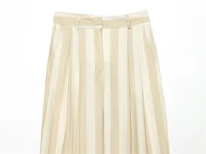Détail de pantalon large à rayures beiges à taille haute avec des plis sur le devant