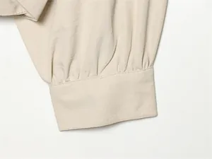 Vue macro détaillée montrant le poignet froncé et les coutures d'une veste à manches lanterne