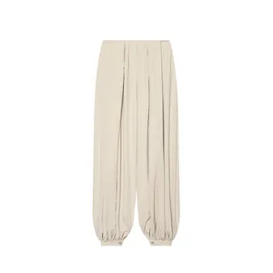 Pantalon bouffant d'été beige léger avec taille plissée et chevilles resserrées.