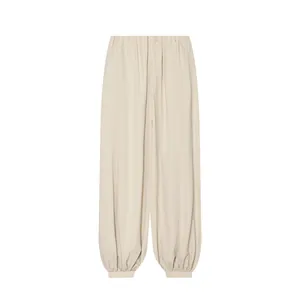 Vue de face d'un pantalon bouffant beige avec taille élastique et chevilles resserrées