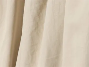 Gros plan détaillé de la texture du tissu sergé beige avec un drapé naturel