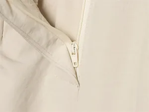 Gros plan détaillé de la fermeture éclair et du tissu du pantalon bouffant beige