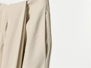 Détail en gros plan du pantalon bouffant beige montrant la texture du tissu