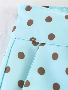Close-up view of light blue polka dot fabric showing detailed stitching and textile texture