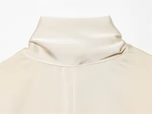 Vue détaillée du col montant d'une robe en satin élégante de couleur crème ivoire lisse