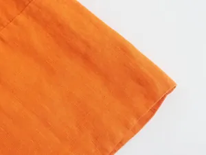 Close-up macro view of orange linen fabric from the summer sleeveless top and pants set