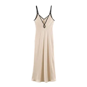 Detailed view of champagne satin slip dress with black contrast trim and V-neckline.