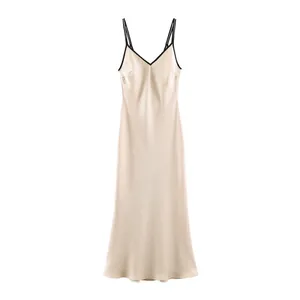 Elegant champagne satin slip dress with contrast black trim and delicate V-neckline detail.