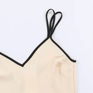 Detail view of women's dress featuring black contrast trim and thin spaghetti straps.