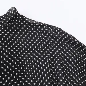 Detailaufnahme aus schwarzem Chiffonstoff mit weißen Punkten für eine elegante Bluse.