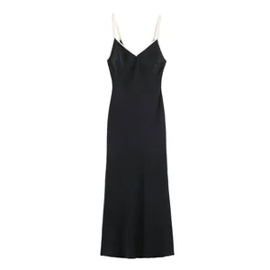 Elegant black slip dress featuring white contrast piping detail and sleek satin finish