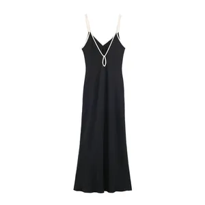 Detail of black slip dress featuring elegant white contrast trim and V-neckline
