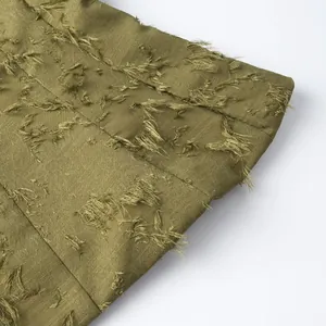 Detailed view of olive green women's top featuring textured fringed jacquard fabric