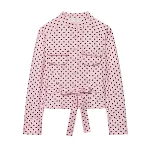Roze shirtjas met lange mouwen, zwarte stippen, opstaande kraag en een strikceintuur