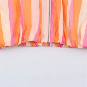 Close-up detail of women's colorful striped summer jacket with zipper and elastic hem.