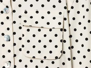 Detailopname van een polka dot overhemdjack met parelmoer knopen en een zakdetail