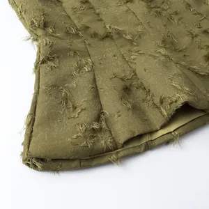 Detailed macro view of olive green distressed fringed jacquard fabric for women's tops