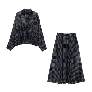 Elegante schwarz-weiße gepunktete Langarmbluse und passendes Set mit A-Linien-Rock.