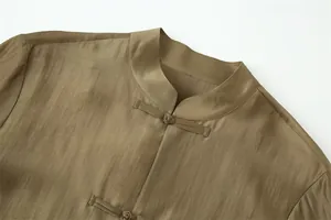 Close-up of mandarin collar and handmade knot buttons on silk-like shirt